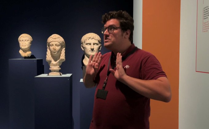 Alexis Dussaix guide sourd, signe devant les bustes en marbre de Marc Antoine, Cléopâtre et Octave dans l'exposition "Le mystère Cléopâtre"