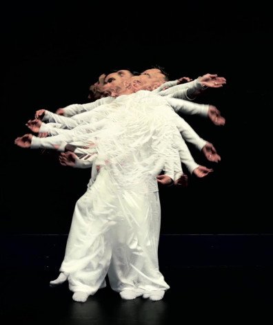 AragoRn Boulanger danse habillé en blanc sur fond noir, le corps du danseur est en mouvement